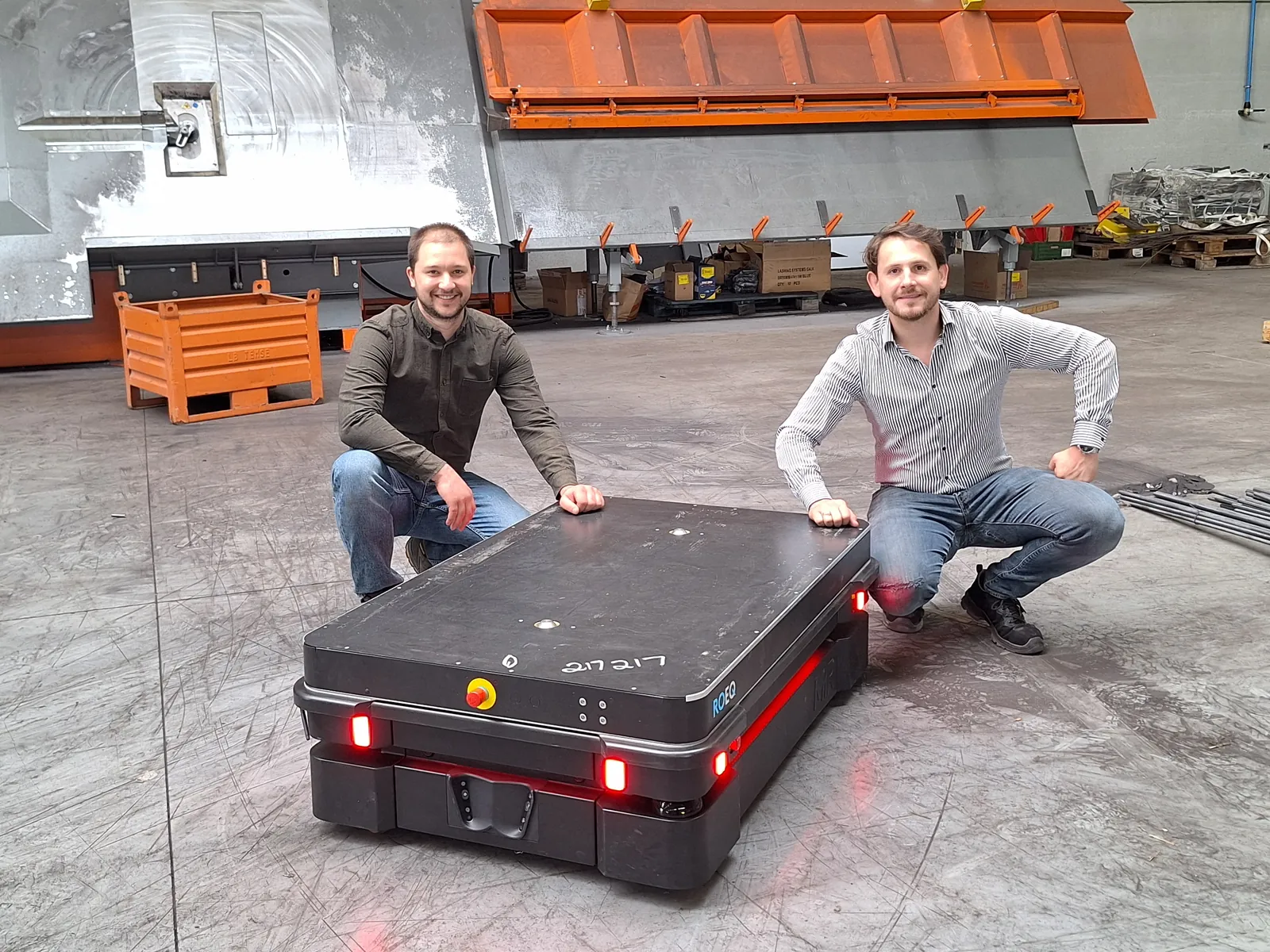 Flow+ co-founders Samuel Reynaert and Maxime Van Daele beside an AMR in a metal fabrication workshop